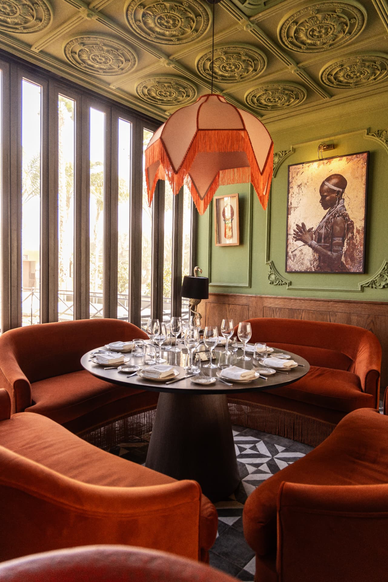 Table ronde et banquettes sous le plafond décoré